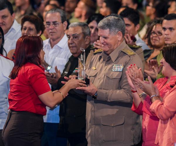 El General de división José. A Carrillo, presidente de la Asociación de Combatientes de la Revolución Cubana (ACRC), recibe de manos de Susely Morfa González, integrante del Comité Central del Partido Comunista de Cuba (CC PCC) y del Consejo de Estado, y primera secretaria de la Unión de Jóvenes Comunistas (UJC), la Medalla Conmemorativa Aniversario 55 de la UJC, durante la gala político-cultural por los 55 años de la organización juvenil y 56 de la Organización de Pioneros José Martí (OPJM), en el teatro Karl Marx, en La Habana, el 4 de abril de 2017. ACN FOTO/Abel PADRÓN PADILLA