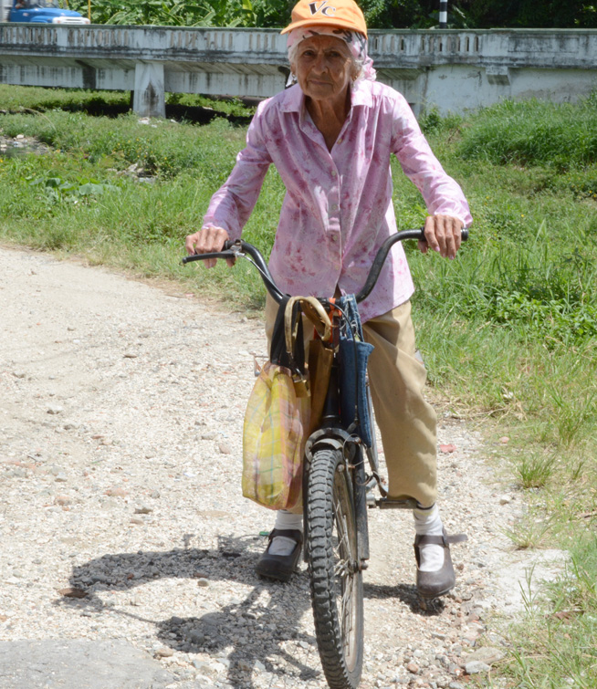 La “súper abuela” con su bicicleta busca yerbas y otros alimentos para sus conejitos.