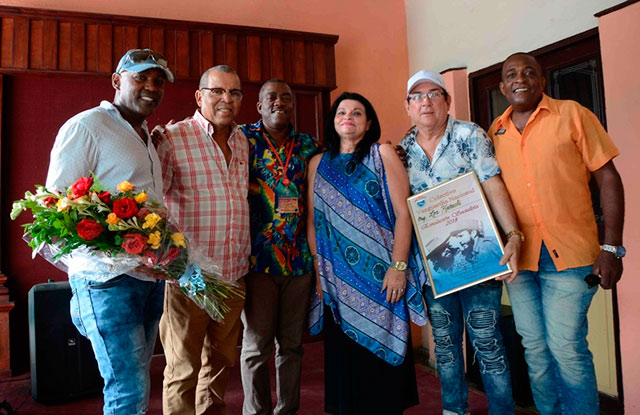 Nereyda López Labrada (C. der.), secretaria General del Sindicato Nacional de Trabajadores de la Cultura, junto a Fernando Álvarez (segundo derecha), tecladista y director de la agrupación musical Los Karachi, junto a otros miembros de la agrupación, luego de recibir el diploma que acredita a la orquesta como Vanguardia Nacional por 15 años consecutivos, en Santiago de Cuba, el 4 de julio de 2019. ACN FOTO/Miguel RUBIERA JÚSTIZ 0704-vanguardia-karachi1.jpg