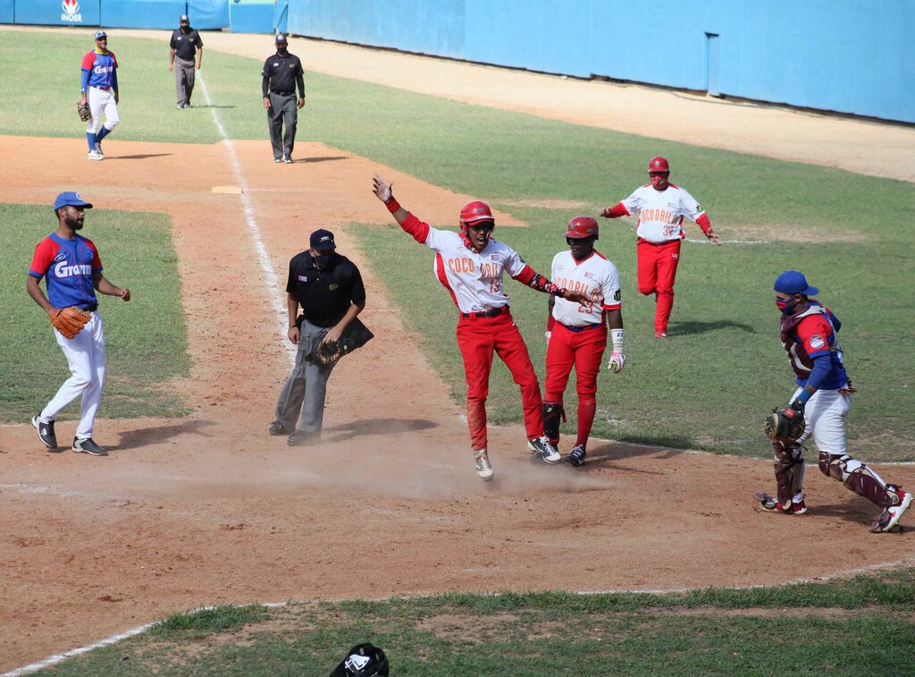 Béisbol: Yoisnel Camejo (centro, uniforma rojo y blanco, saltando) anotó por wild pitch la carrera que le dió la victoria a Matanzas sobre Granma en el quinto juego de la final beisbolera cubana que se desarrolla en el estadio José Antonio Huelga, en Sancti Spíritus, Cuba, el 2 de abril de 2021. ACN FOTO/Oscar ALFONSO SOSA
