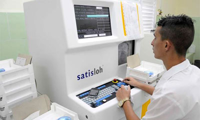 Laboratorio de Tallado de Lentes Oftalmológicos, perteneciente al Grupo Empresarial Artemisa. AIN FOTO/ Roberto MOREJÓN RODRÍGUEZ Técnico opera un equipo, en el Laboratorio de Tallado de Lentes Oftalmológicos, perteneciente al Grupo Empresarial Artemisa (GEA), en la provincia de Artemisa, Cuba, 25 de junio de 2014. AIN FOTO/ Roberto MOREJÓN RODRÍGUEZ