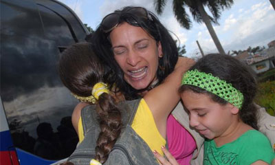 Niñas reciben a su mamá, médico colaboradora en Brasil, que retorna de vacaciones, en Bayamo. AIN FOTO/Armando Ernesto CONTRERAS TAMAYO Niñas le dan un abrazo de bienvenida a su mamá, médico colaboradora perteneciente al primer grupo que partió a Brasil, que retorna de vacaciones, en la ciudad de Bayamo, provincia de Granma, Cuba, el 2 de julio de 2014. AIN FOTO/Armando Ernesto CONTRERAS TAMAYO