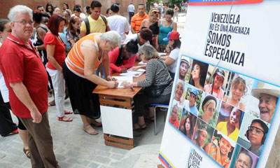 Participantes en la recogida de firmas en rechazo a la política intervencionista de Estados Unidos y exigiendo que se revoque la Orden Ejecutiva firmada por el Presidente Barack Obama que considera a Venezuela como una amenaza para la seguridad nacional del país norteño, en la Casa Simón Bolívar de La Habana, Cuba, el 31 de marzo de 2015.AIN FOTO solidaridad_venezuela_firmas.jpg